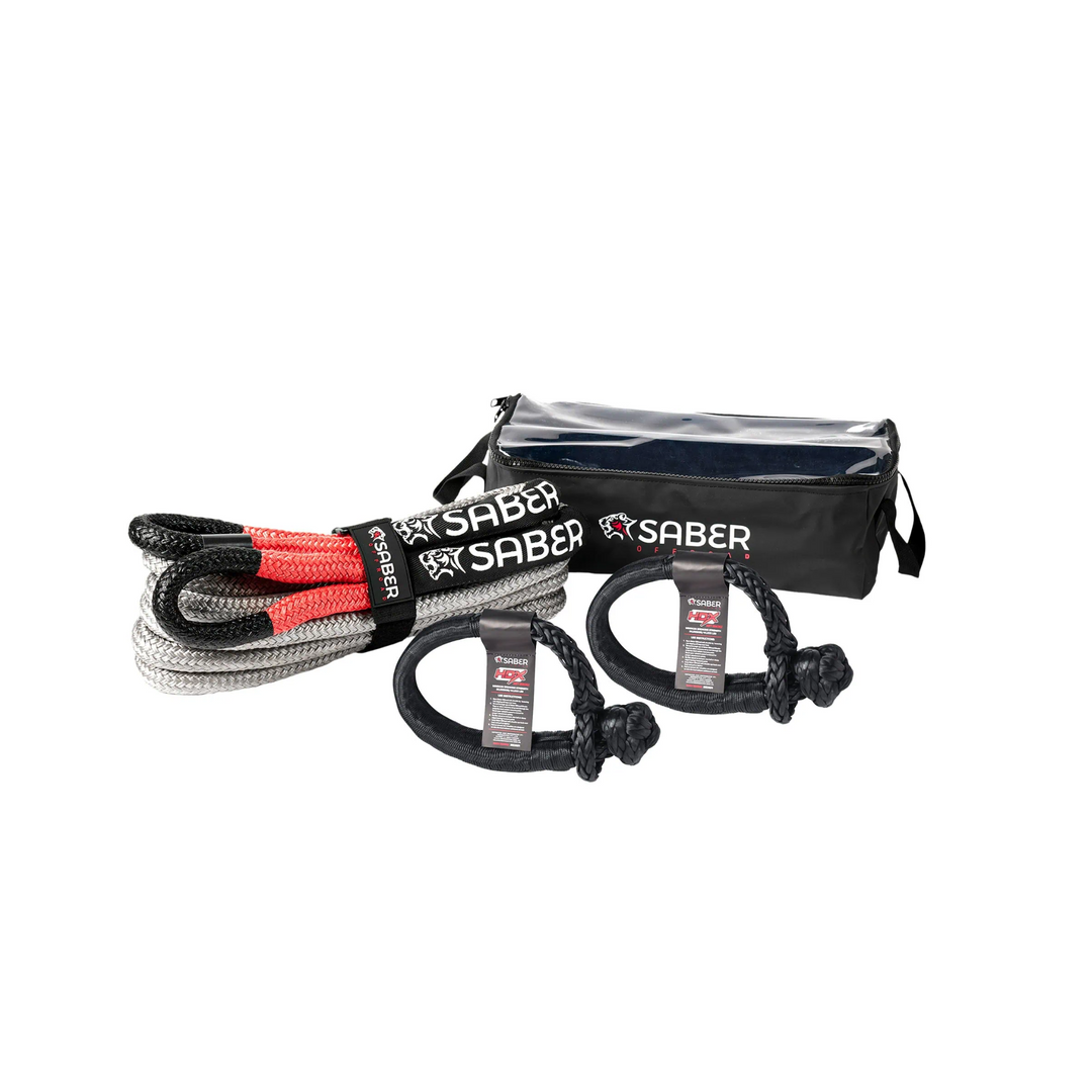 A Saber brand heavy duty kinetic recovery kit including a black and gray rope with red detailing, two black and gray soft shackles, and a black carry bag with the brand logo.